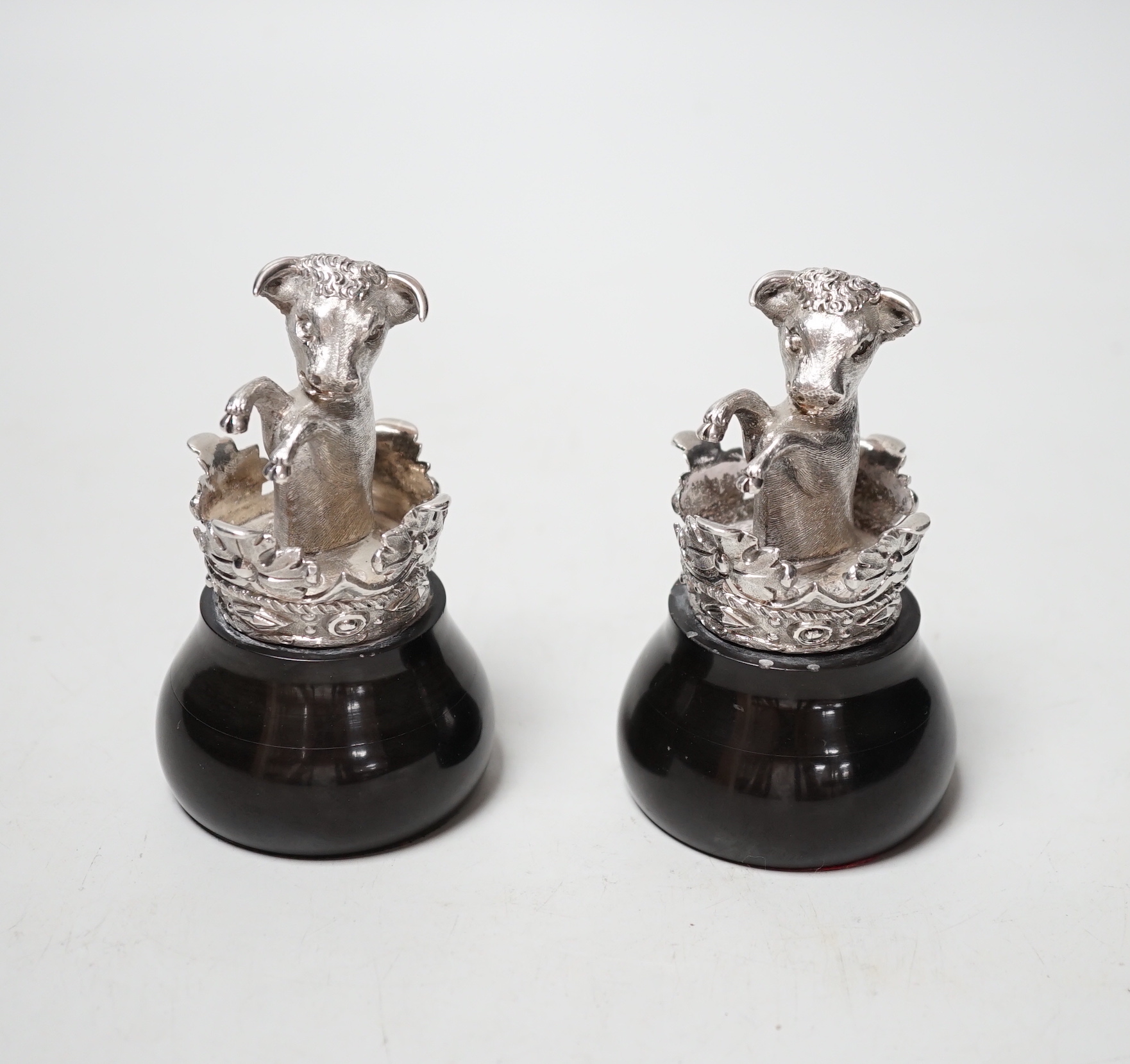 A pair of silver heraldic crests, modelled as rearing bull's within a coronet, on ebonised bases, probably copies of the pediments at Eridge Park, Kent, Mitchell Bosley & Co?, Birmingham, 1899, height 95mm.